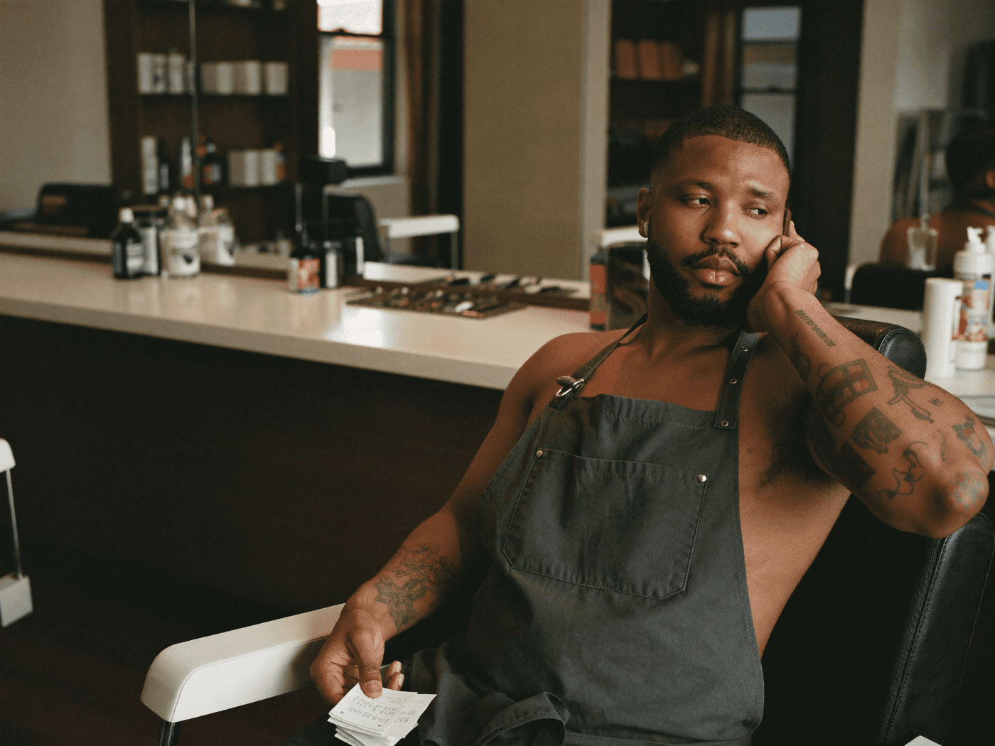 A barber checking booking apps late at night after the shop has closed
